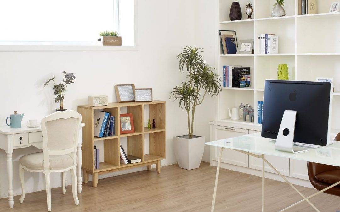 Home office with desk, bookshelves, and hardwood floors
